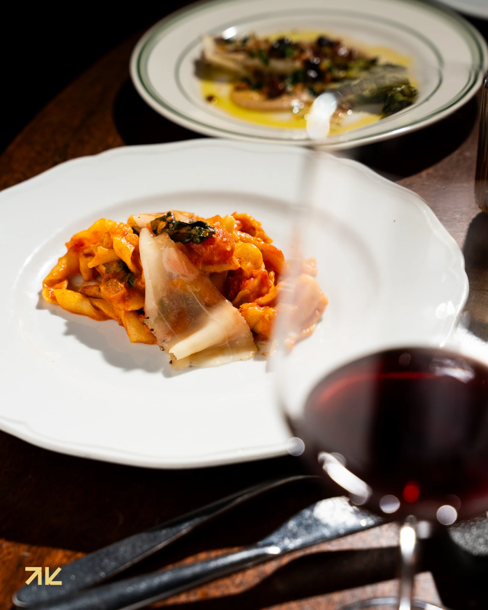 Pasta servida con vino tinto en la mesa de Macchialina